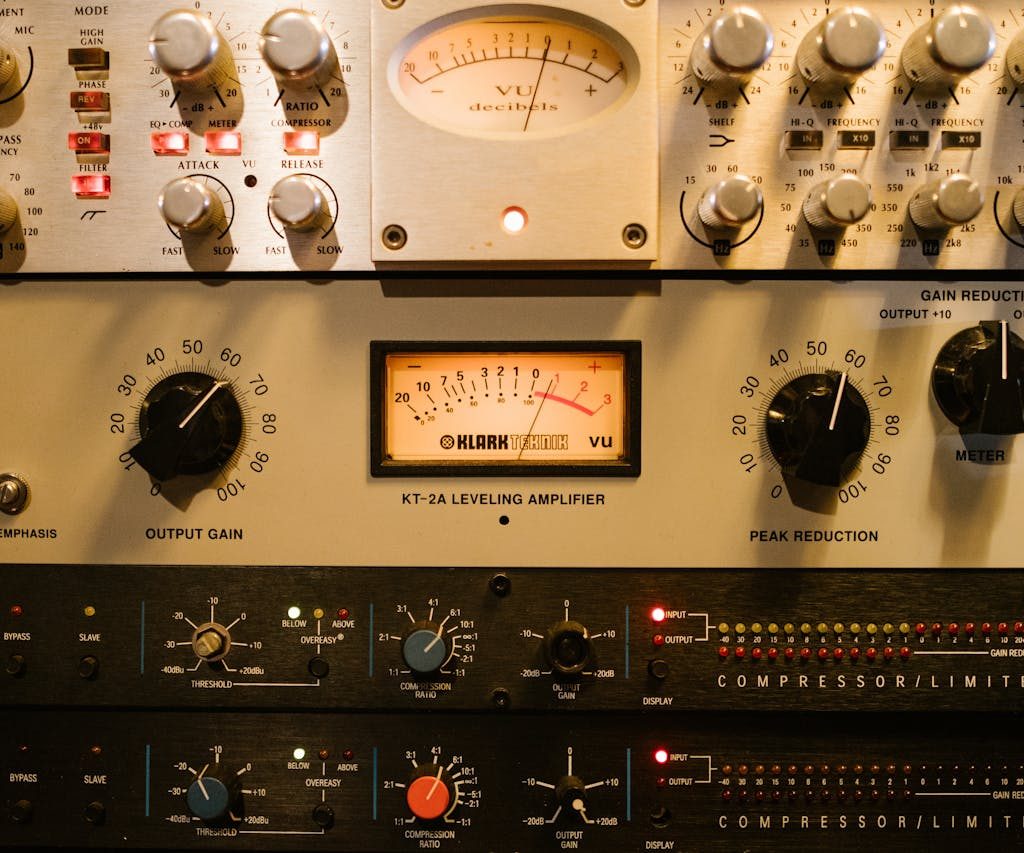 Close-up of audio amplifiers and compressors in a music studio setup.