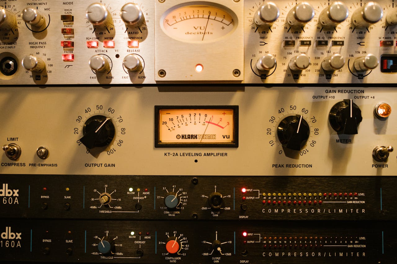 Close-up of audio amplifiers and compressors in a music studio setup.